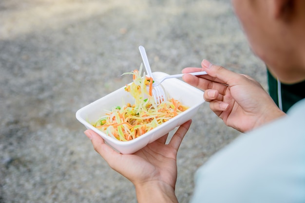 Les gens mangent de la salade de papaye, de la nourriture de rue.