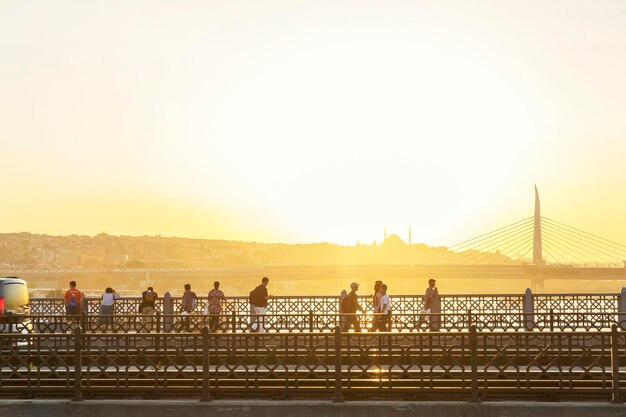 Les gens marchant et admirant le magnifique coucher de soleil jaune vif sur un beau pont Beau paysage Istanbul Turquie 05232019