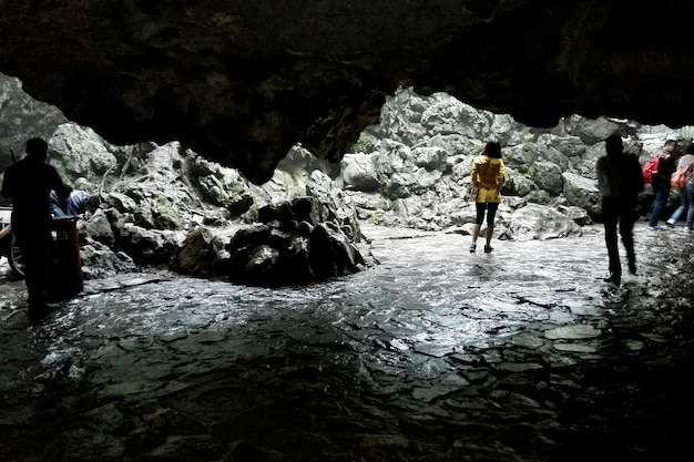 Photo des gens marchant sur un champ humide vus depuis la grotte