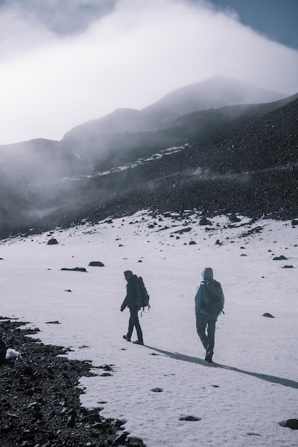 Photo des gens marchant sur une terre couverte de neige en hiver