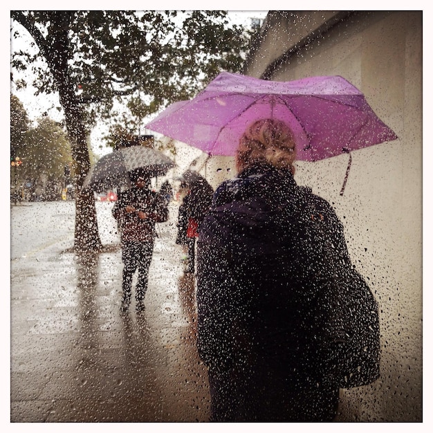 Photo des gens marchant sur le trottoir pendant la mousson