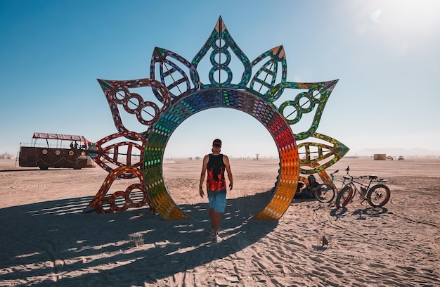 Les gens marchant vers le coucher du soleil lors d'un festival dans le désert