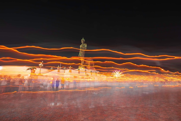 Les gens marchent avec des bougies allumées à la main autour d'un temple