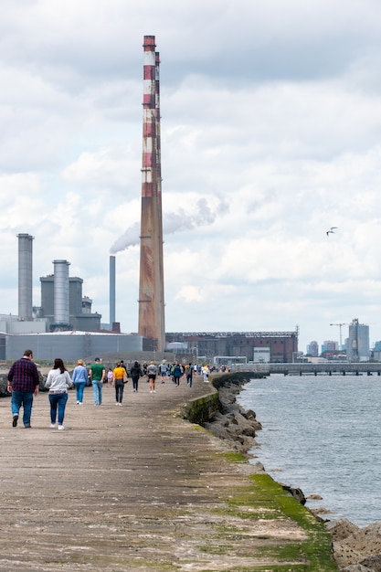 Les gens marchent sur la grande promenade sud au phare de Pollbeg.