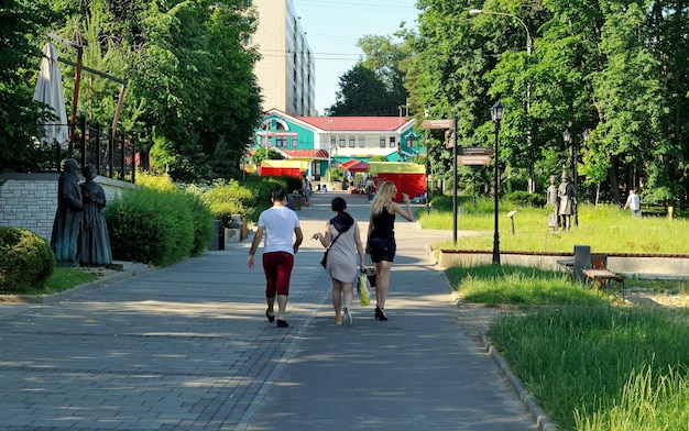 Les gens marchent le long de la rue piétonne de la ville un matin d'été ensoleillé