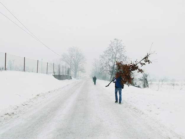 Des gens marchent sur une route couverte de neige.