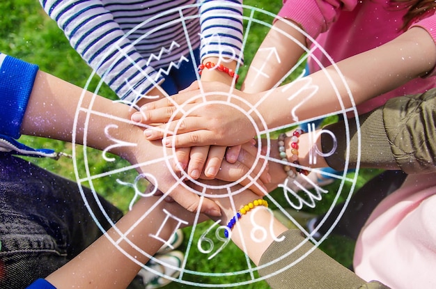 Photo les gens mettent leurs mains ensemble signe du zodiaque mise au point sélective