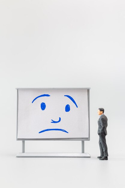 Photo des gens en miniature un homme d'affaires abattu est positionné devant un tableau blanc le concept du lundi bleu le jour le plus déprimant de l'année