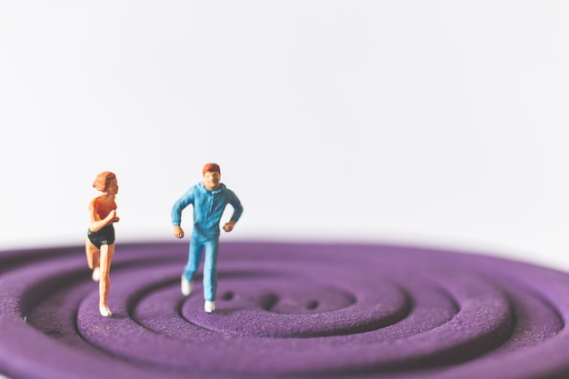 Gens miniatures: Couple en cours d&#39;exécution sur le champ violet