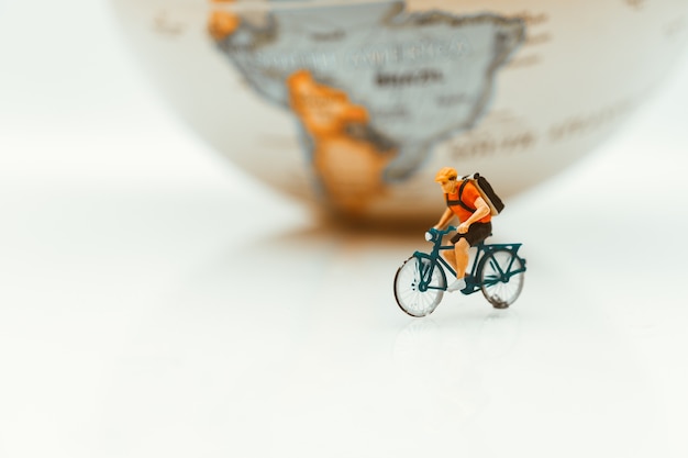 Gens miniatures, homme cyclisme sur fond de terre en utilisant comme concept de compétition et sport