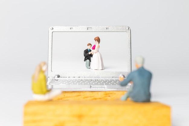 Gens miniatures Mariée et marié mariage virtuel sur écran d'ordinateur, concept Happy Valentines Day