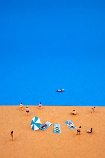 Gens miniatures sur la plage d'été