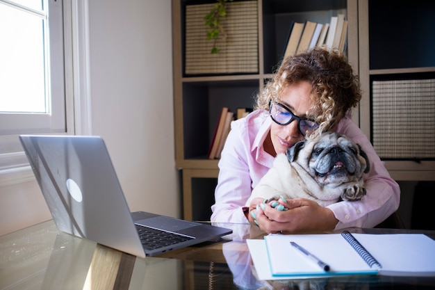 Les gens modernes et les chiens aiment le style de vie dans un travail intelligent à la maison avec un ordinateur portable et une connexion Internet