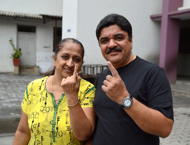 Les gens montrent leurs doigts marqués à l'encre après avoir voté