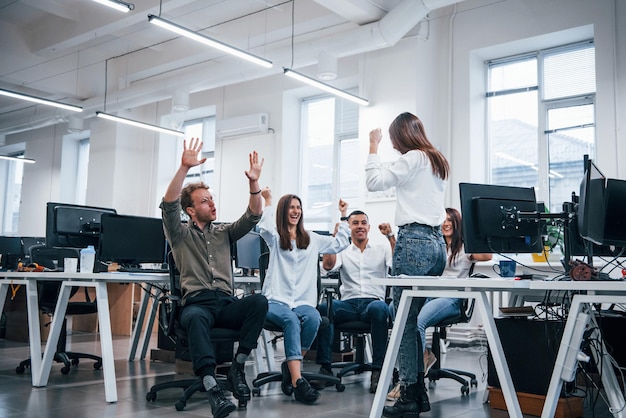 Les gens parlent et travaillent ensemble dans le bureau moderne près des ordinateurs.