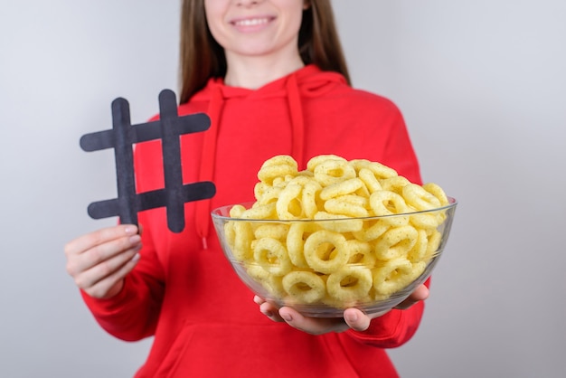 Les gens partagent le concept de temps libre. Photo en gros plan recadrée de positif joyeux satisfait cool bonne jolie jolie fille tenant un bol avec des chips rondes fond gris isolé