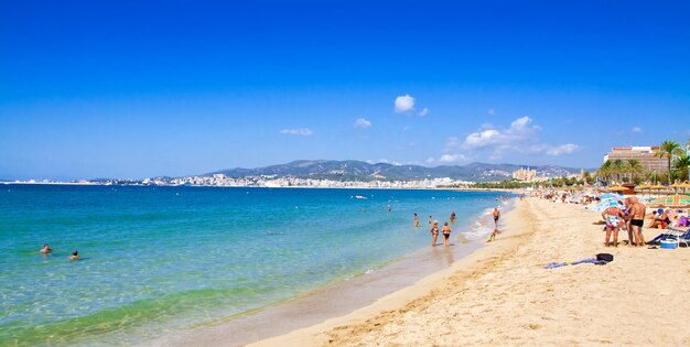 Photo des gens sur la plage contre le ciel bleu