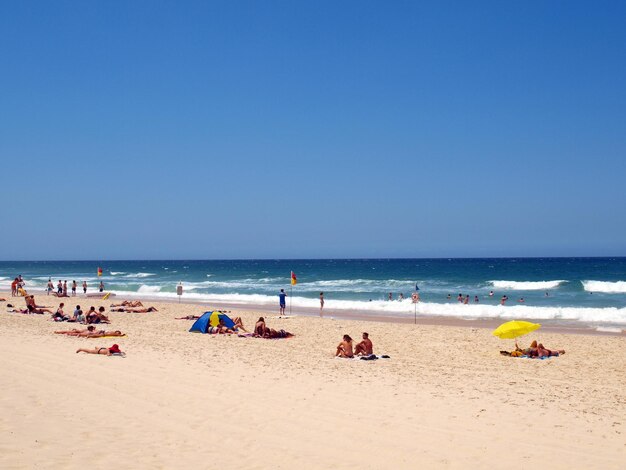 Des gens sur la plage contre le ciel