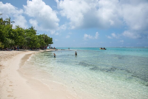 Des gens sur la plage contre le ciel