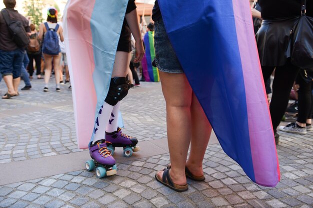 Des gens portant le drapeau de l'arc-en-ciel pendant le défilé en ville