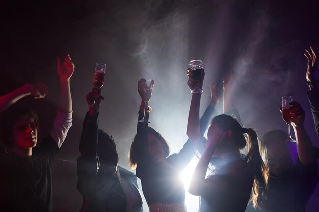 Les gens qui dansent dans le club rétroéclairé