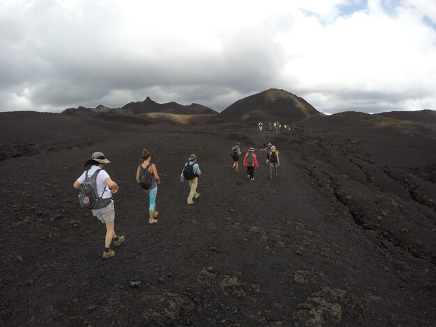 Photo des gens qui marchent sur un paysage stérile.