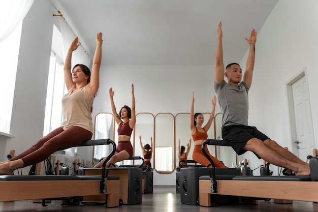 Photo les gens qui suivent des cours de pilates réformateur