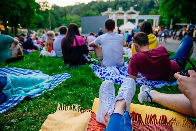 Photo des gens regardent un film dans un cinéma en plein air dans un parc de la ville.