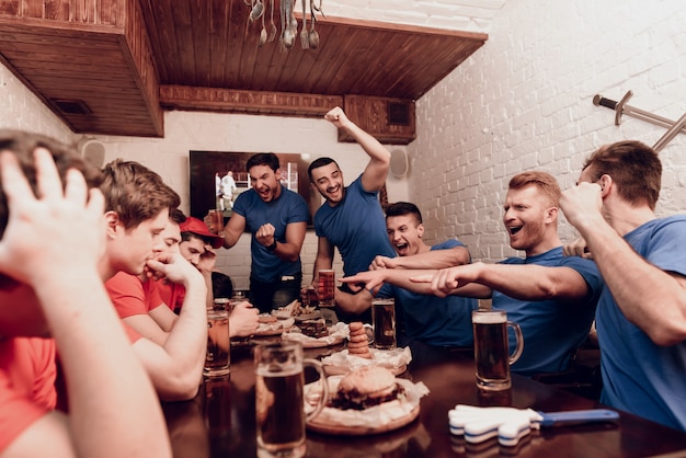 Les gens regardent un match de football à la télévision.