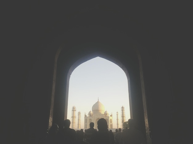 Les gens regardent le Taj Mahal à travers l'arc.