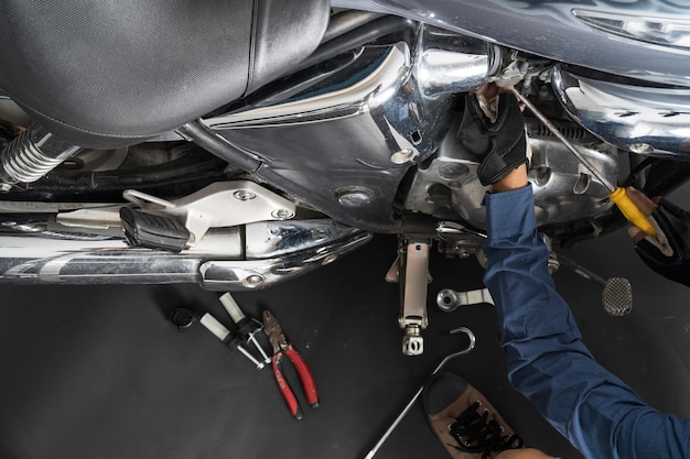 Les gens réparent une moto Utilisez une clé et un tournevis pour travailler