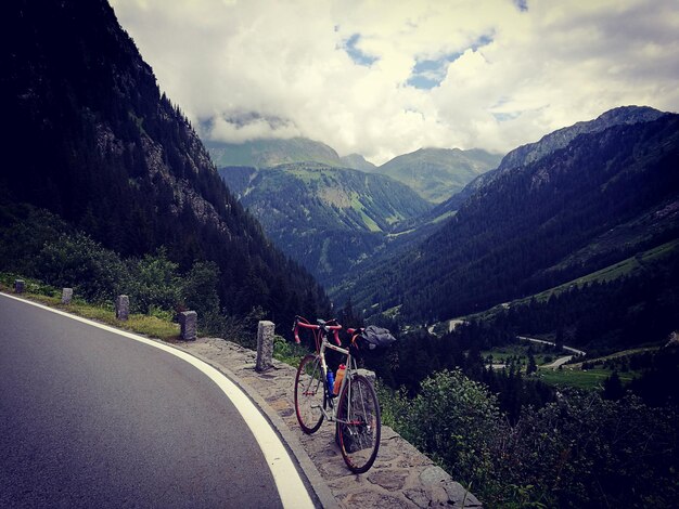 Des gens sur la route par les montagnes contre le ciel