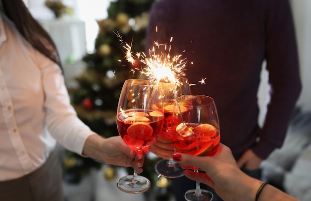 Les gens saluent les cocktails du nouvel an avec des cierges magiques à une partie