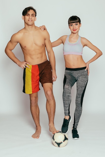 Gens de santé Concept de sport et de style de vie Jeunes sportifs couple femme et homme en studio Jeune et belle femme athlétique et homme sur fond gris