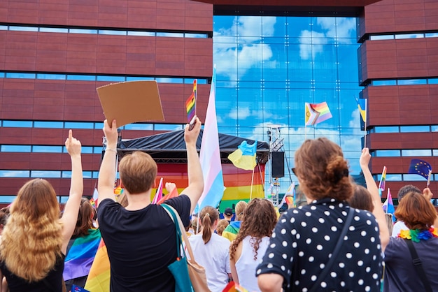 Les gens se pressent avec des drapeaux arc-en-ciel LGBTQ lors d'une manifestation de fierté