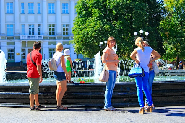 Les gens se reposent dans le parc de la ville avec des fontaines Les gens profitent du week-end dans le parc de la ville près des fontaines Repos en famille Concept de voyage Chaude journée d'été