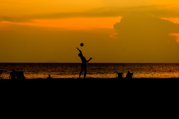 Les gens de silhouette jouent au beach-volley.