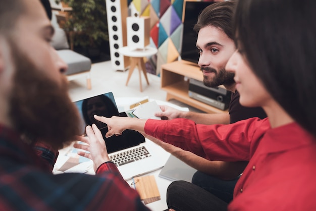 Les gens sont assis à table et regardent quelque chose sur la tablette