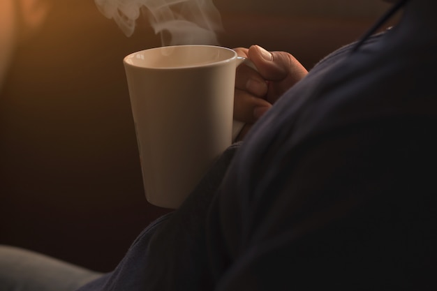 Les gens tiennent une tasse de café blanche