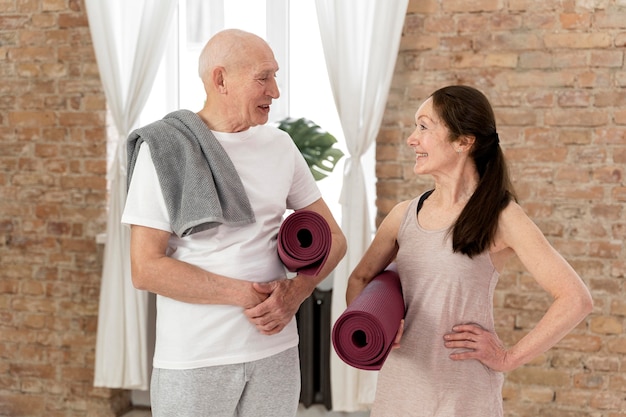 Photo gens de tir moyen avec des tapis de yoga