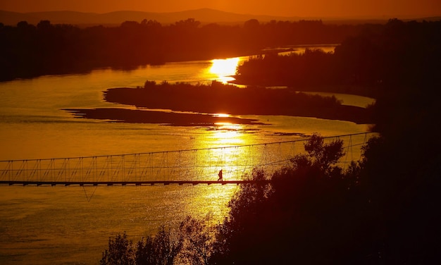 Les gens traversent le paysage de la scène de l'heure d'or du pont-levis dans le Xinjiang en Chine