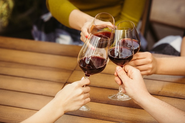 Les gens trinquent avec du vin sur la terrasse d'été du café ou du restaurant.