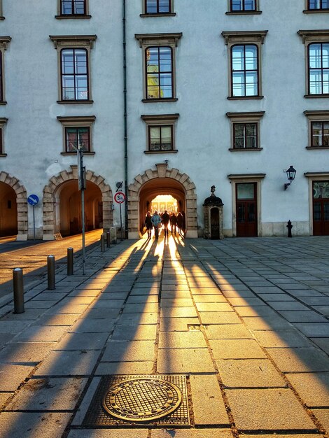 Photo des gens sur le trottoir au milieu des bâtiments de la ville