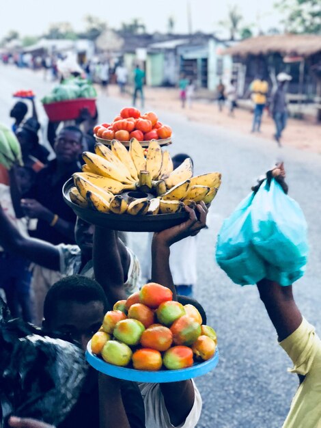 Photo des gens vendant des fruits et des légumes au marché.