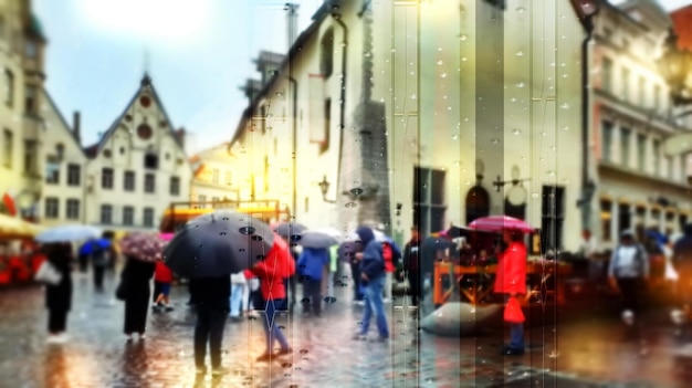 Les gens de la ville pluvieuse marchent avec des parapluies maisons médiévales touristiques dans la vieille ville de Tallinn par temps froid