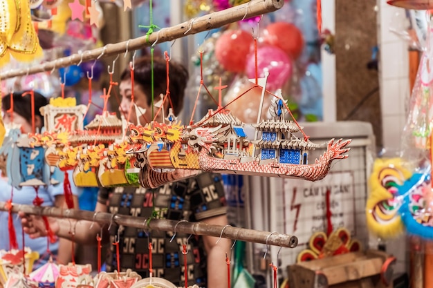 Les gens visitent et achètent des lanternes traditionnelles colorées suspendues pendant la fête de la mi-automne