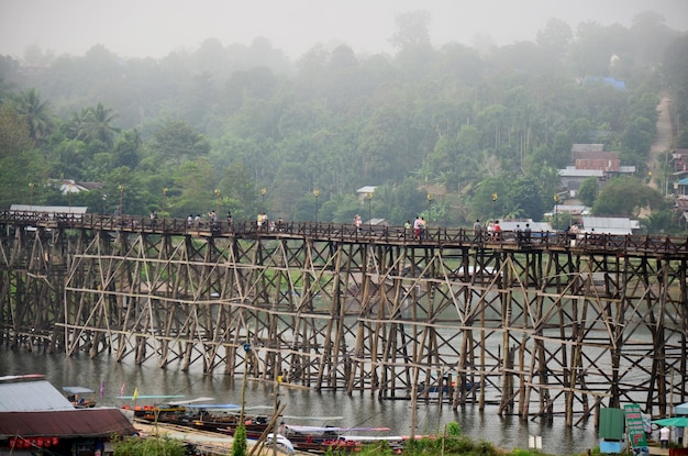 Les gens voyagent et attendent sur le pont en bois de Saphan Mon le matin à Sangkhlaburi le 4 décembre 2015 à Kanchanaburi en Thaïlande