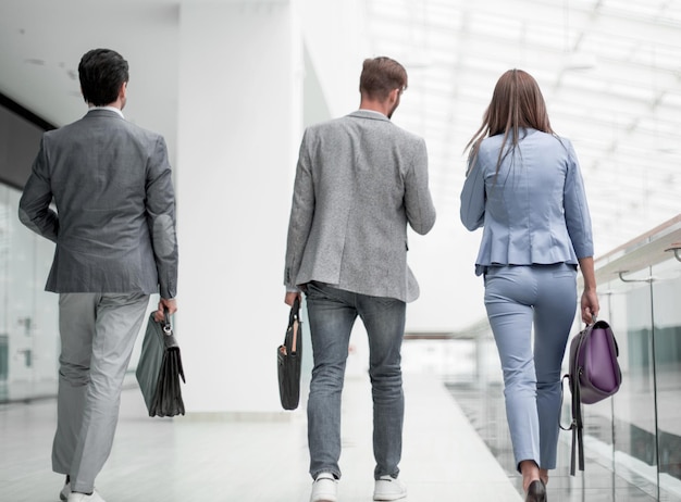 Les gens de vue arrière marchent dans l'immeuble de bureaux