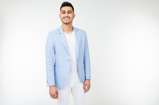 Gentilhomme souriant dans une veste bleue posant sur un fond blanc avec copie espace