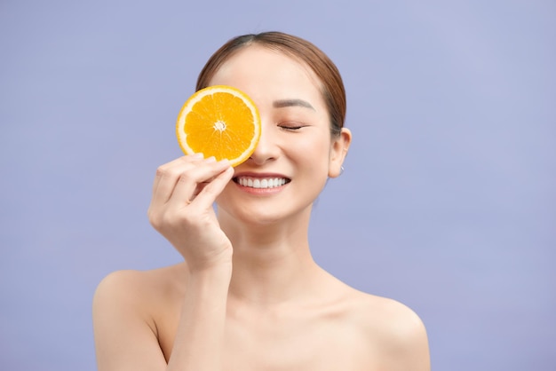 Gentille Fille Riante Avec Des Tranches D'orange Devant Son Oeil